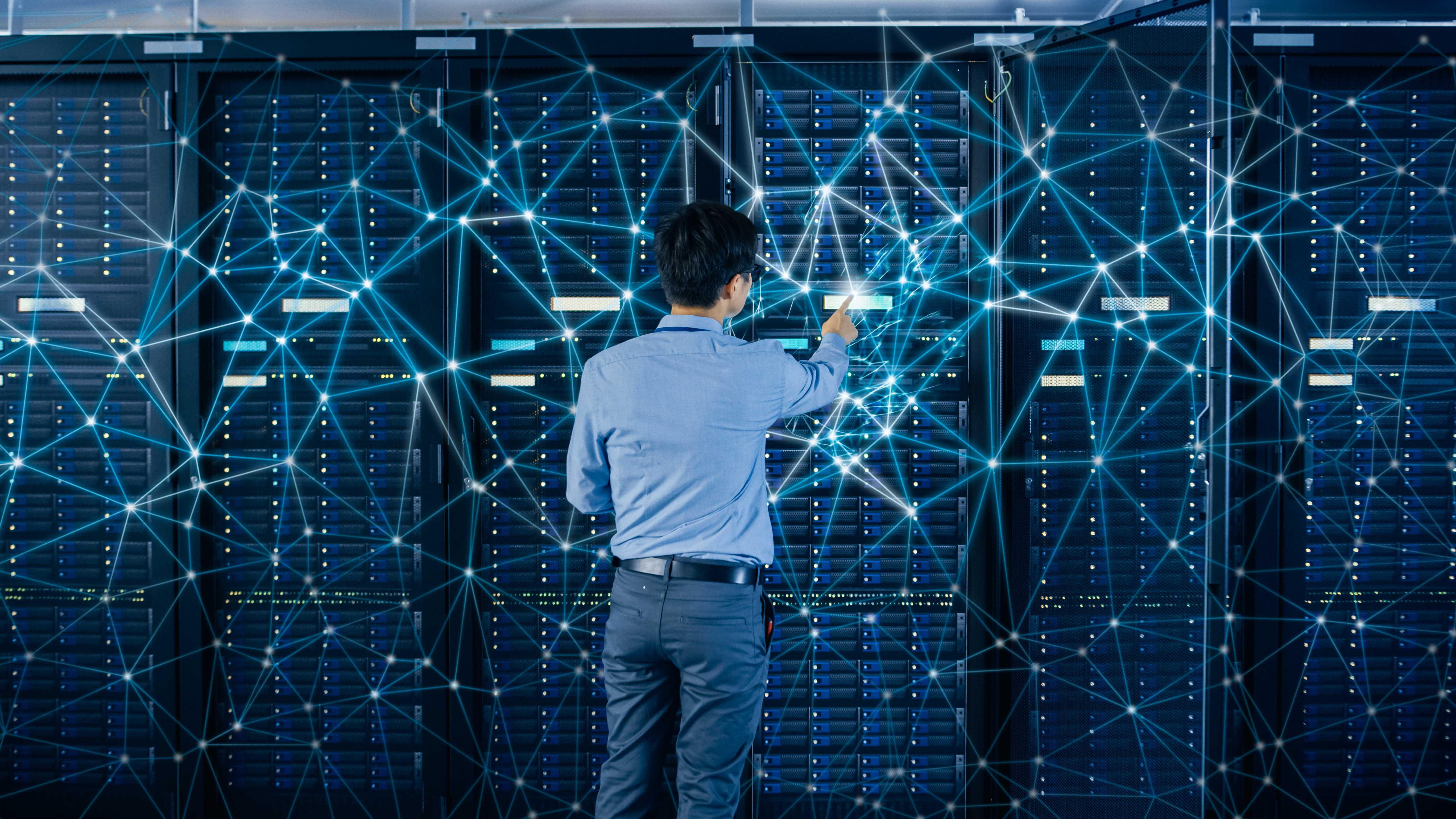 Internet Web Concept. Shot In the Modern Data Center: IT Engineer Standing Beside Open Server Rack Cabinets and Touching Digital Connections on a Server.